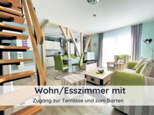 ein Wohnzimmer mit einer Treppe und grünen Möbeln in der Unterkunft DolceVita - mit eingezäuntem Garten - WLAN - 2 Terrassen - gern mit Hund in Walkenried