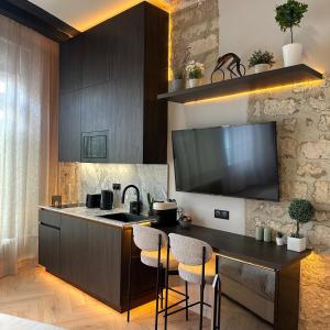 a kitchen with a sink and a counter with stools at SAINT-LOUIS APARTMENT - LUXURY HIGH END RENOVATED Apartment - HEART OF LE MARAIS - HOTEL DE VILLE in Paris