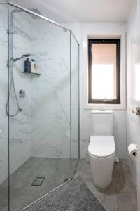 W łazience znajduje się toaleta i przeszklony prysznic. w obiekcie Lovely 4 bedrooms house to Ed station w mieście Ingleburn