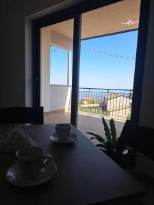 a table with two coffee cups and a view of a balcony at Villa Corina in Vaccarizzo Albanese