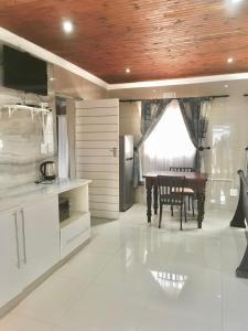 eine Küche mit einem Tisch und einem Esszimmer in der Unterkunft P & T Guesthouses in Pietermaritzburg