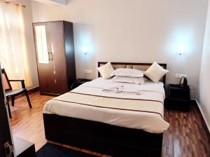 a bedroom with a large bed with white sheets at Hotel Sonar Tori in Gangtok