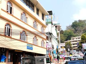 a busy city street with cars parked in front of a building at Hotel Sonar Tori in Gangtok