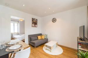 ein Wohnzimmer mit einem Sofa und einem Tisch in der Unterkunft Escale paisible appartement proche Guingamp in Grâces