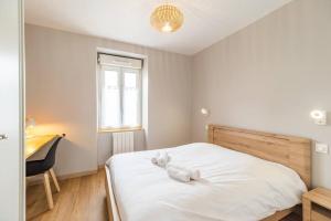ein Schlafzimmer mit einem Bett mit zwei ausgestopften Tieren darauf in der Unterkunft Escale paisible appartement proche Guingamp in Grâces