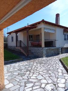 a house with a stone patio in front of it at Polis Houses in Nea Iraklia