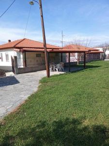 a house with a patio with a table and chairs at Polis Houses in Nea Iraklia