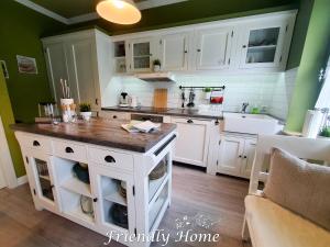 eine Küche mit weißen Schränken und einer Insel darin in der Unterkunft Friendly Home - Stadthaus in Bornheim + 8 Fotos