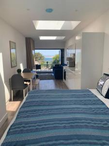 a bedroom with a bed and a kitchen with a view at Carbis Daze Studio Super Kingsize bed Carbis Bay in Carbis Bay