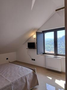 a bedroom with a bed and a large window at Villa Corina in Vaccarizzo Albanese