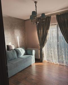 uma sala de estar com um sofá e uma janela em Casa Mara em Cristian