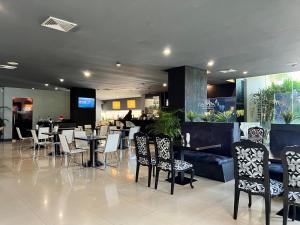 Hotel GH Guaparo INN في Naguanagua: غرفة طعام مع طاولات وكراسي في مطعم