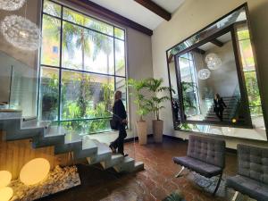 a woman walking down a staircase in a lobby at Hotel GH Guaparo INN in Naguanagua