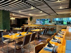 a restaurant with wooden tables and chairs and a kitchen at Hotel GH Guaparo INN in Naguanagua