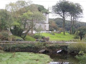 uma casa em uma colina com uma ponte e um lago em Durrus em Durrus