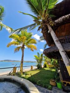 un complexe avec une piscine et des palmiers sur la plage dans l'établissement Ô Bleu Azur, à Antsatrakolo