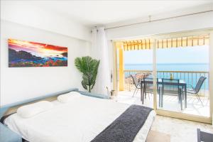 een slaapkamer met een bed en uitzicht op de oceaan bij Roquebrune plage - Terrasse vue mer in Roquebrune-Cap-Martin