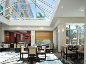 a dining room with tables and chairs and windows at DoubleTree by Hilton San Diego Del Mar in San Diego