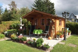 ein winziges Haus in einem Garten mit einem Brunnen in der Unterkunft Oma Hennys Bergnest in Clausthal-Zellerfeld