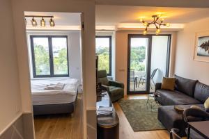 een woonkamer met een bank en een bed bij Apartments Royal - Sakura Park in Novi Beograd