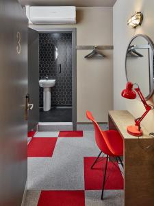 ein Badezimmer mit einem roten Stuhl und einem WC in der Unterkunft The Pier Rooms in Oban
