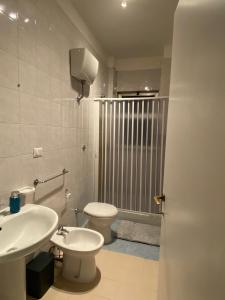 a bathroom with a white toilet and a sink at Home 22 in Brindisi