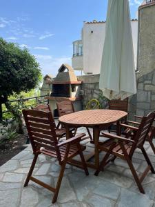 un tavolo in legno e due sedie con ombrellone di Peaceful Escape a Kavala