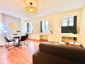 a living room with a couch and a table at Brest Centre - Appartements - Le Vauban - Lumineux - Centre Ville - Proche Boutiques et Restaurants in Brest