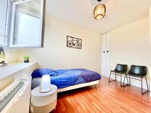 a bedroom with a bed and two black chairs at Brest Centre - Appartements - Le Vauban - Lumineux - Centre Ville - Proche Boutiques et Restaurants in Brest