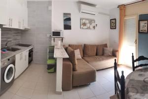 a kitchen and a living room with a couch and a table at Apartamento El Hammam in Empuriabrava