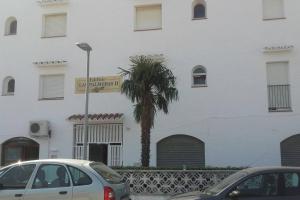two cars parked in front of a white building with a palm tree at Apartamento El Hammam in Empuriabrava