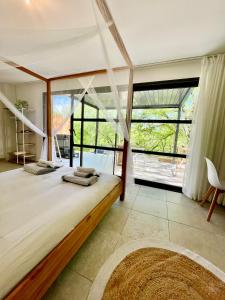 a bedroom with a large bed with a large window at Côté nature in Chauzon