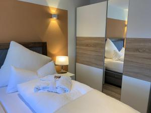 um quarto com uma cama branca e um espelho em Harzfewo Köhnke 2 em Goslar