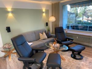 uma sala de estar com um sofá e duas cadeiras e uma mesa em Harzfewo Köhnke 2 em Goslar