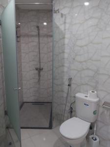 a bathroom with a shower with a toilet and a glass door at Appartement de luxe Haut Founty in Agadir +12 photos