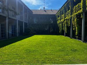 a large yard with green grass next to a building at Loft G Hospitality in Milan