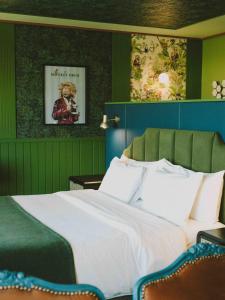 a bedroom with a large bed with green walls at Hotel Eco Boutique Bidasoa in Santiago