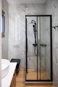 uma casa de banho com uma cabina de duche em vidro e um lavatório. em Kefalovriso Luxury Apartment 1 em Lepanto