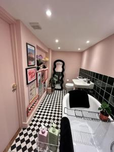 uma casa de banho com uma banheira branca e um piso em xadrez preto e branco. em The Basement em Brighton & Hove