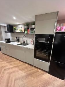uma cozinha com um frigorífico preto e um lavatório em The Basement em Brighton & Hove