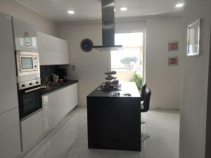 a kitchen with a black island in the middle at oplonti home in Boscotrecase