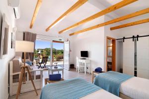 1 dormitorio con 2 camas, escritorio y mesa en Quinta Tapada dos Machados, en Alvor