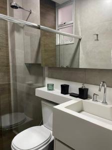 a bathroom with a toilet and a sink and a mirror at Lindo apartamento em Copacabana in Rio de Janeiro