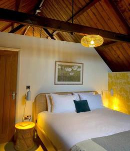 a bedroom with a white bed and a chandelier at Tin tabernacle perfect for group getaways in Chale