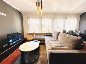 a living room with a couch and a tv at Keli Apartments Zentrum Oldenburg in Oldenburg