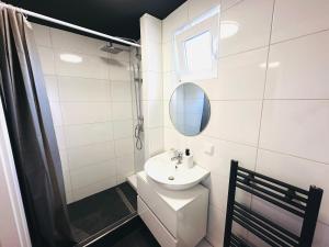 uma casa de banho branca com um lavatório e um espelho em Keli Apartments Zentrum Oldenburg em Oldenburg