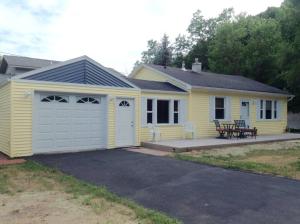 uma pequena casa amarela com uma garagem branca em Cozy Quiet Gem Near Sheridan Beach em Michigan City