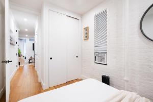 a bedroom with white walls and a large window at 1288-3RS New Renovated 2 Bedrooms in New York