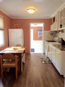 eine Küche mit einem Tisch und einem weißen Kühlschrank in der Unterkunft Cozy Quiet Gem Near Sheridan Beach in Michigan City