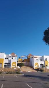 uma fila de edifícios brancos e amarelos ao lado de uma rua em Calme Cozy appartement/Tamaris em Casablanca